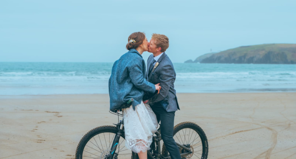wedding couple in bicycle at a beach close to Dunowen House
